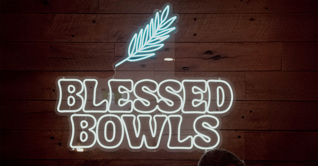 Blessed Bowls white neon on a reclaimed wood café wall